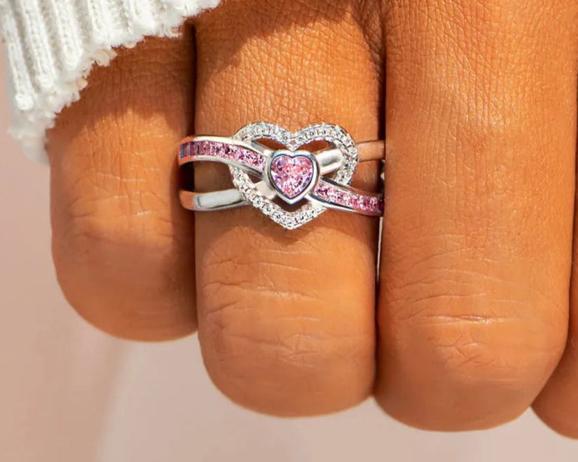 Heart-shaped zircon ring with 925 sterling silver band and pink gemstone, pave halo accent stones on finger