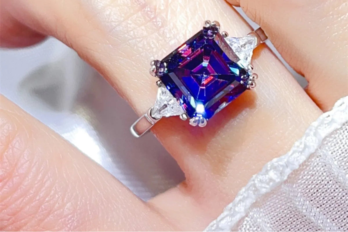 3 carat moissanite 925 sterling silver ring with purple emerald-cut center stone and side stones, high-polish ring on finger